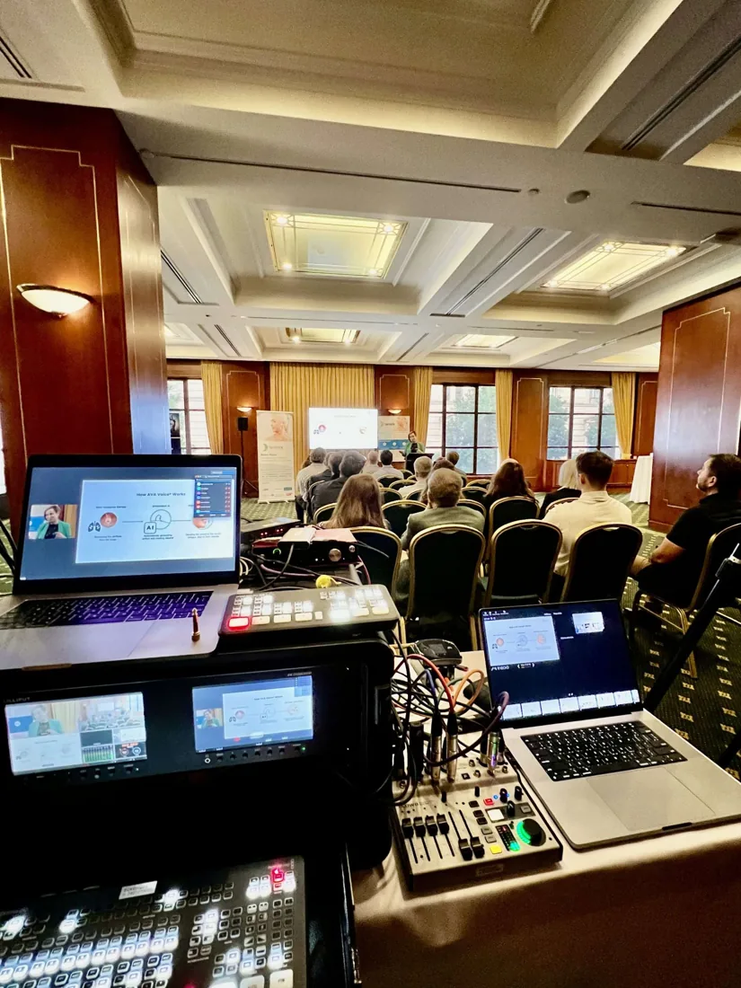 Vision switching desk and two laptops set up at the back of a hotel conference room
